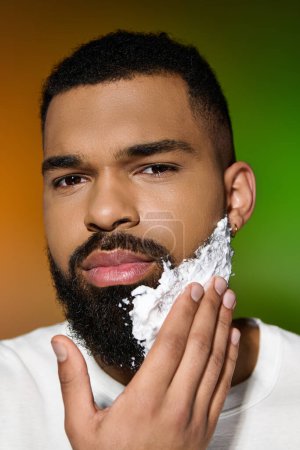 Photo for Young man closely shaves his face as part of a skincare routine. - Royalty Free Image