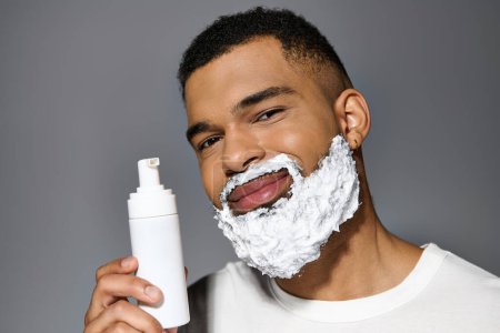 Hombre guapo con barba sostiene la botella de afeitar.