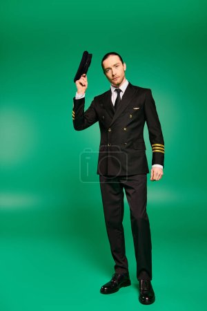 A stylish pilot in a black suit confidently waving with hat.