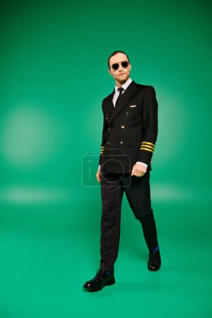 Un pilote élégant en costume noir et lunettes de soleil se dresse avec confiance sur un fond vert vif.