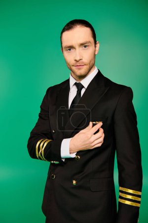 Handsome male pilot in a suit and tie posing on a green backdrop.