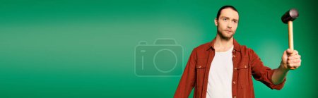 Téléchargez les photos : Un homme en bois de forme uniforme avec un maillet sur un fond vert. - en image libre de droit