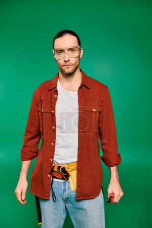 Photo for Handsome worker in uniform with glasses on green backdrop. - Royalty Free Image