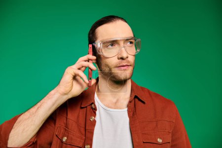 A man in glasses makes a phone call.