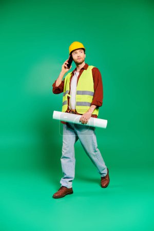 A man in a hard hat and safety vest talking on a cell phone.