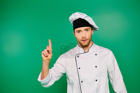 Handsome chef in white uniform confidently pointing towards the camera.