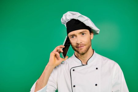 Male chef in white uniform talking on cell phone.