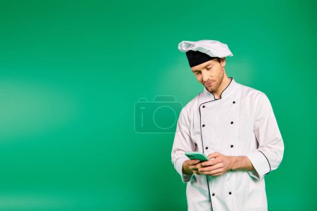 A male chef in white uniform holding a cell phone.