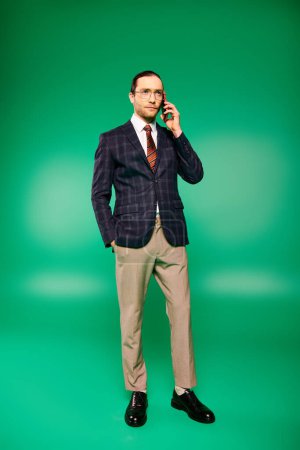Téléchargez les photos : Un bel homme d'affaires en costume chic engagé dans une conversation téléphonique. - en image libre de droit