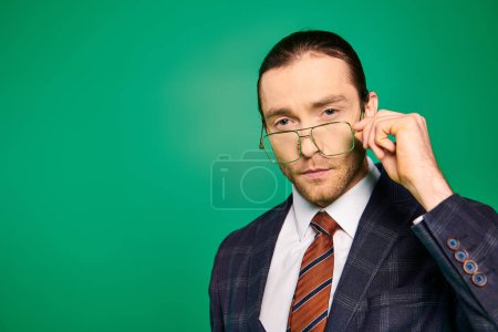 Foto de Hombre adecuado levanta las gafas pensativamente. - Imagen libre de derechos