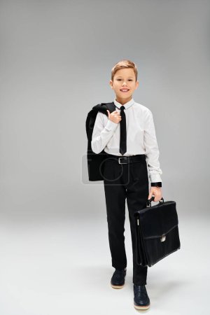 Un joven elegante con traje y corbata sostiene con confianza un maletín.
