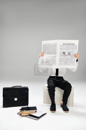 Téléchargez les photos : Man in elegant attire reading newspaper while sitting on bench. - en image libre de droit