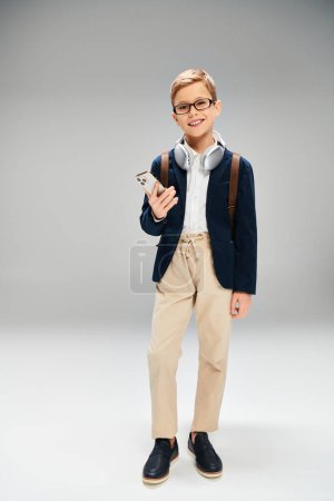 A preadolescent boy wearing glasses and a blue jacket.