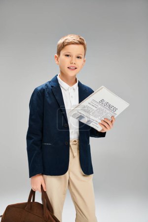 Ein stilvoller kleiner Junge mit Aktentasche und Papier.