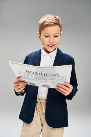 A stylish young boy in a suit deeply engrossed in reading a newspaper.