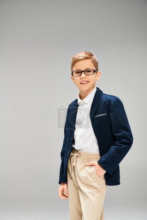 Vorpubertärer Junge in stylischem Anzug und Brille, der Selbstbewusstsein und Raffinesse ausstrahlt.
