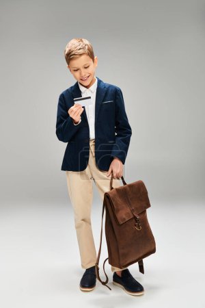 Kleiner Junge im Anzug mit Aktentasche.