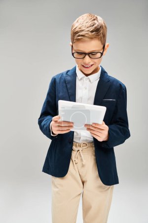 A young boy in a suit and glasses, holding a tablet, embodies the future of business.