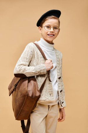 A cute preadolescent boy dressed as a film director, wearing glasses and a hat.