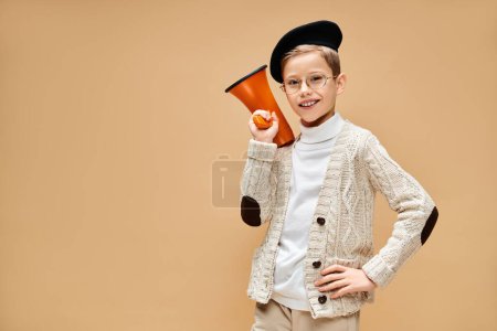 Young boy in film director costume, holding a megaphone.