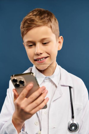 Téléchargez les photos : Garçon en blanc médecins manteau détient téléphone cellulaire. - en image libre de droit