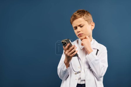 Niño en bata de laboratorio blanco cautivado por la pantalla del teléfono inteligente.