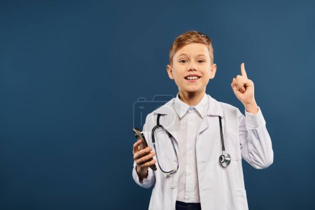 Young boy in doctors coat pointing enthusiastically.