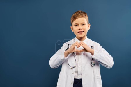 Young boy in white lab coat forming heart shape with hands.