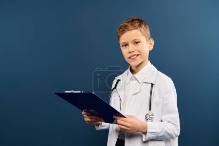 Young boy in a doctors coat writing on a clipboard.