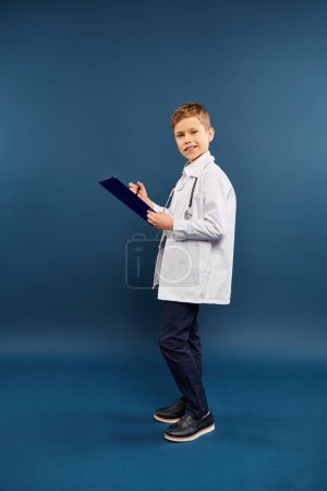 A preadolescent boy in a lab coat holding a clipboard.