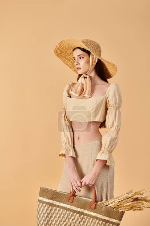 Una mujer joven con el pelo largo y morena posa serenamente en un traje de verano, sosteniendo una canasta mientras usa un sombrero elegante.