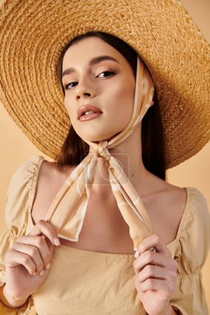 Une jeune femme aux longs cheveux bruns pose en tenue d'été, vêtue d'un chapeau et d'une écharpe en paille, respirant une ambiance sereine et ensoleillée.