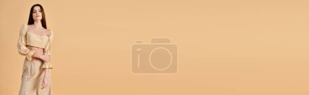Téléchargez les photos : Une jeune femme aux longs cheveux bruns pose dans une tenue estivale, respirant une ambiance décontractée et stylée devant un fond beige. - en image libre de droit