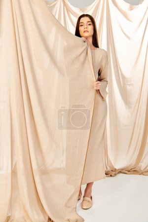 Photo for A young woman stands confidently in front of a vibrant curtain, embodying a carefree summer mood. - Royalty Free Image