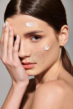 A young woman with brunette hair poses in a studio setting, delicately holding her hand up to her face in a contemplative gesture. Stickers 709768676