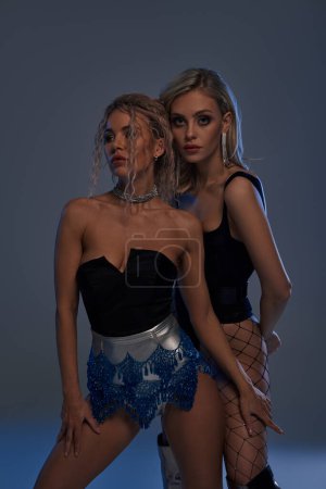 Foto de Dos mujeres jóvenes seductoras hacen una pose glamurosa juntas, exudando confianza y estilo. - Imagen libre de derechos