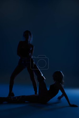 Foto de Dos mujeres jóvenes atractivas dan una pose sensual mientras se paran una al lado de la otra, exudando encanto y confianza. - Imagen libre de derechos