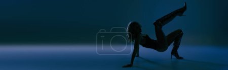 Foto de Una mujer sin esfuerzo realiza un soporte de mano en la oscuridad, mostrando gracia y fuerza en una pose impresionante. - Imagen libre de derechos
