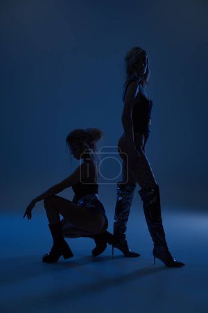 Foto de Dos mujeres jóvenes sexy de pie de cerca, exudando confianza y encanto mientras posan juntos. - Imagen libre de derechos