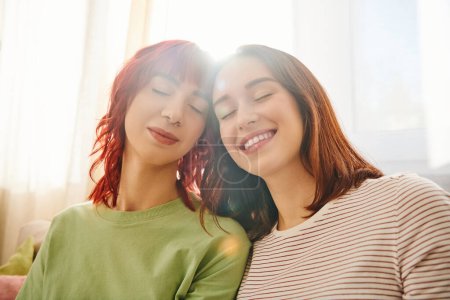 Foto de Sonrisas radiantes iluminan los rostros de la feliz pareja lesbiana, el calor de su amor y la luz del sol - Imagen libre de derechos
