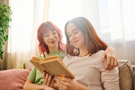 glückliches lesbisches Paar genießt ruhigen Moment des gemeinsamen Lesens, umhüllt von Liebe und Komfort