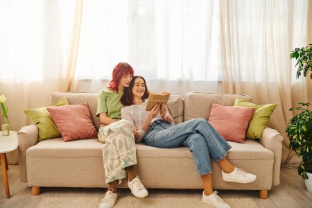 positive lgbt Paar genießt ruhigen Moment des gemeinsamen Lesens, in Liebe und Komfort gehüllt