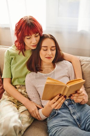 zufriedenes lgbt Paar genießt ruhigen Moment des gemeinsamen Lesens, umhüllt von Liebe und Komfort
