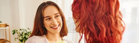 Photo for Happy lesbian woman looking at her girlfriend and smiling in living room, horizontal banner - Royalty Free Image