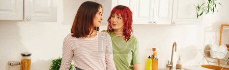 Téléchargez les photos : Intimate kitchen scene with a loving young lesbian couple sharing a moment of connection, banner - en image libre de droit