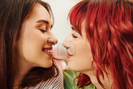 Téléchargez les photos : Portrait de heureux couple lesbien souriant à l'autre tout en ayant moment confortable et doux sur le lit - en image libre de droit