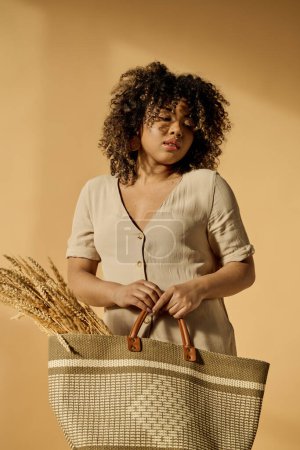 Téléchargez les photos : A beautiful young African American woman with curly hair holding a basket with a handle in a studio setting. - en image libre de droit