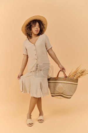 Téléchargez les photos : Une jeune Afro-Américaine vêtue d'une robe d'été et d'un chapeau, tenant gracieusement un panier dans un décor de studio. - en image libre de droit