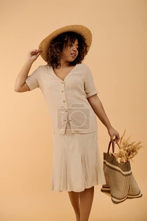 Foto de Una hermosa joven afroamericana con el pelo rizado, vestida con un vestido de verano y sombrero, sostiene una canasta en un ambiente de estudio. - Imagen libre de derechos