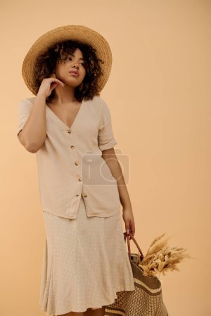 A stylish young African American woman, with curly hair, wearing a summer dress and a wide-brim hat, holding a bag.